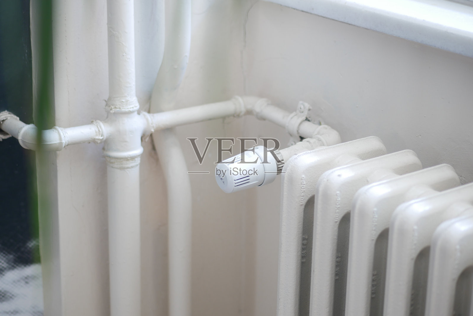 白色散热器安装在灰白色墙壁上,公寓供暖系统。照片摄影图片