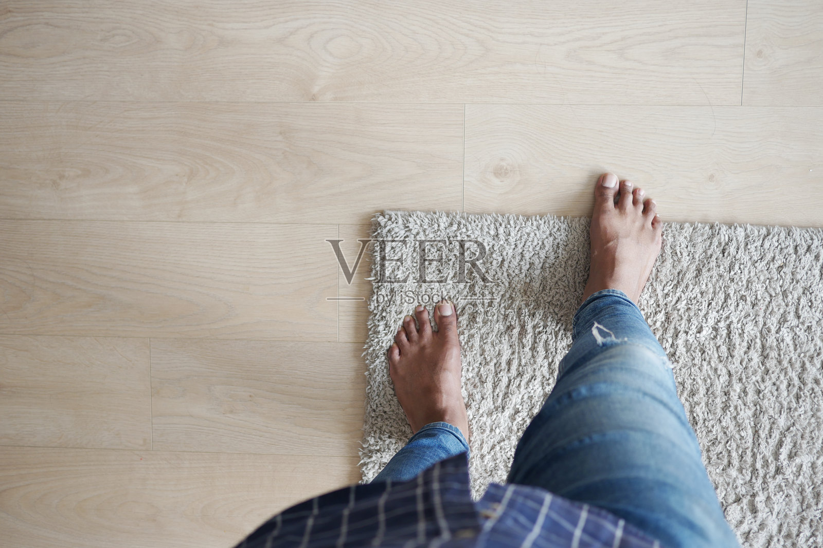 一个休闲的家居环境,脚踩在柔软的地毯上,旁边是美丽的木地板照片摄影图片