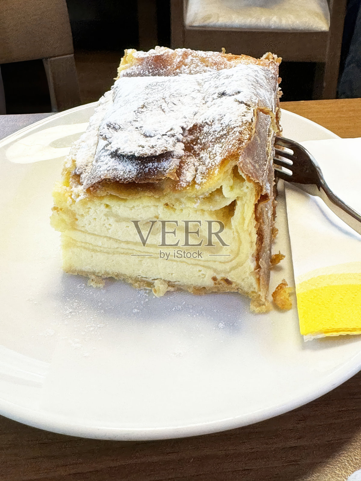 咖啡馆环境中白色盘子上的奶油糕点,撒上糖粉照片摄影图片