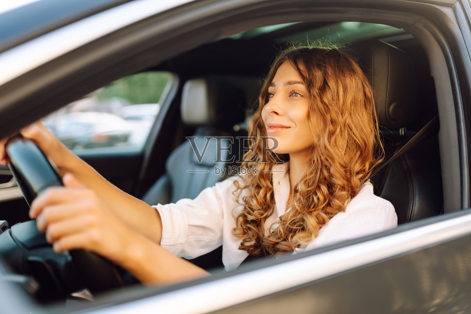 年轻女性自信地驾驶车辆,系着安全带。照片摄影图片