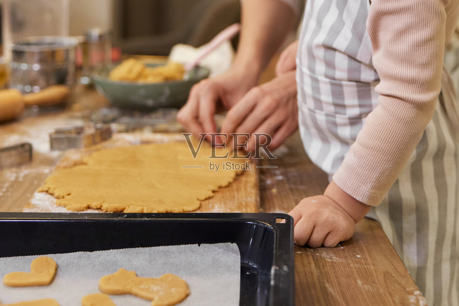 母亲和小女儿正在切割生姜饼面团做饼干照片摄影图片