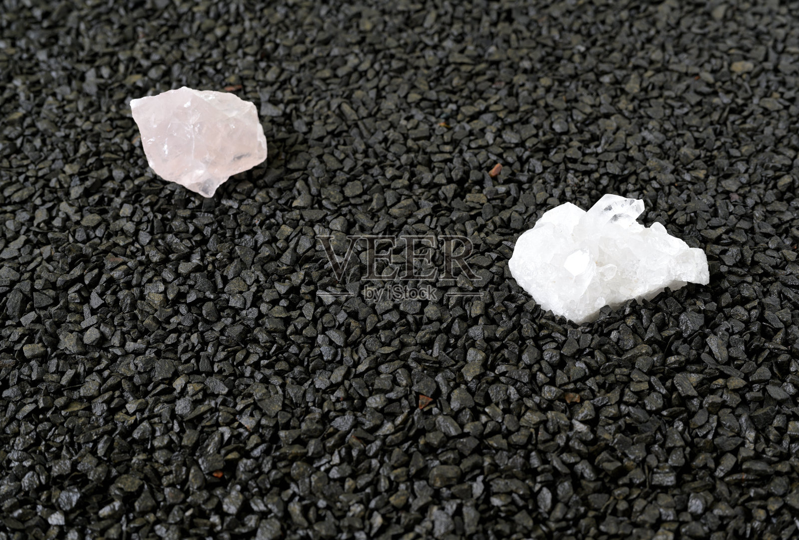 湿润的深色花岗岩碎石上的白色和粉色石英照片摄影图片