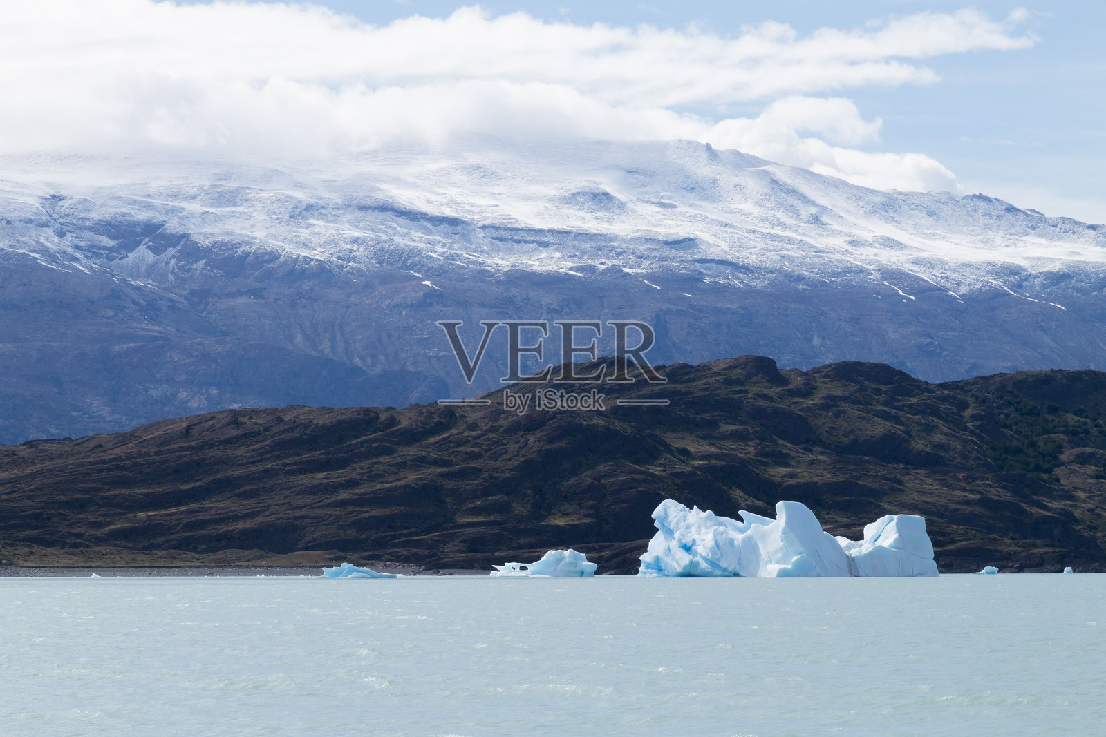 宁静湖泊中的冰山与雪山相映成趣。照片摄影图片