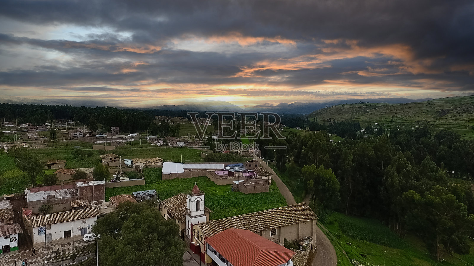 黄昏时的安第斯村庄:安第斯山脉下的教堂与戏剧性的天空照片摄影图片