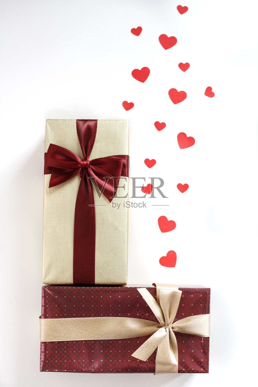 情人节概念,白色背景上有缎带礼品盒和红色心形纸屑。俯视图,留白空间。照片摄影图片