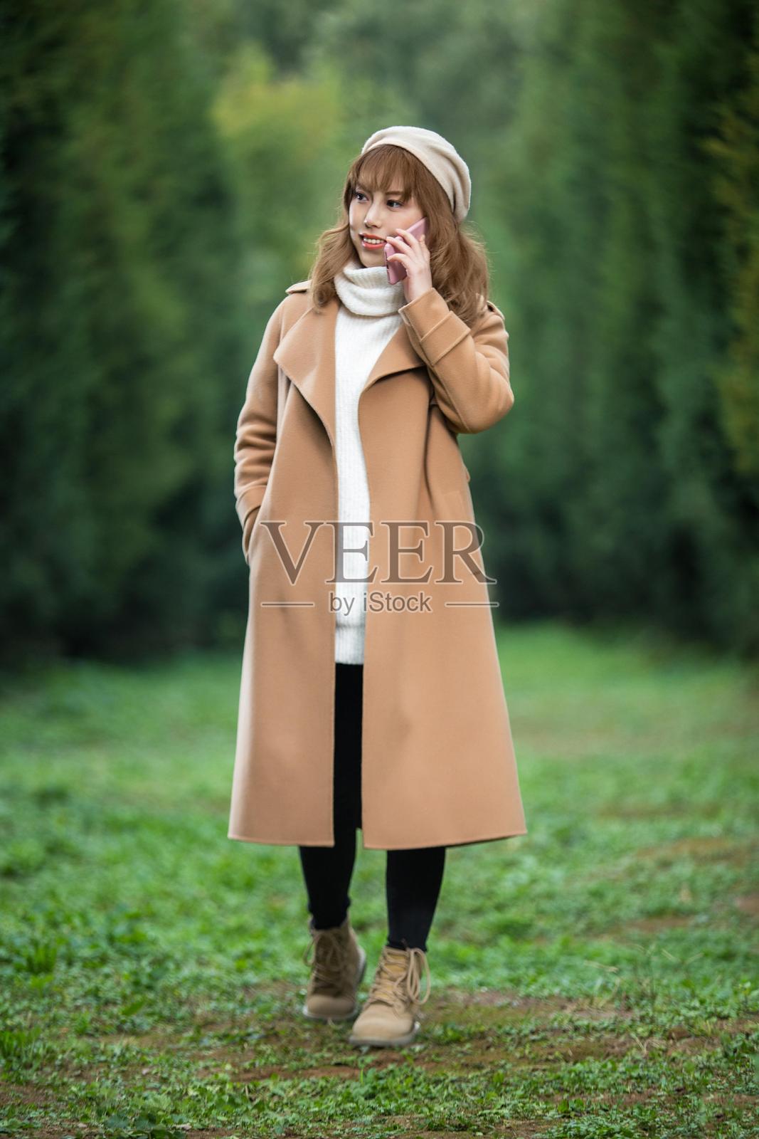 年轻女性在公园里打电话照片摄影图片