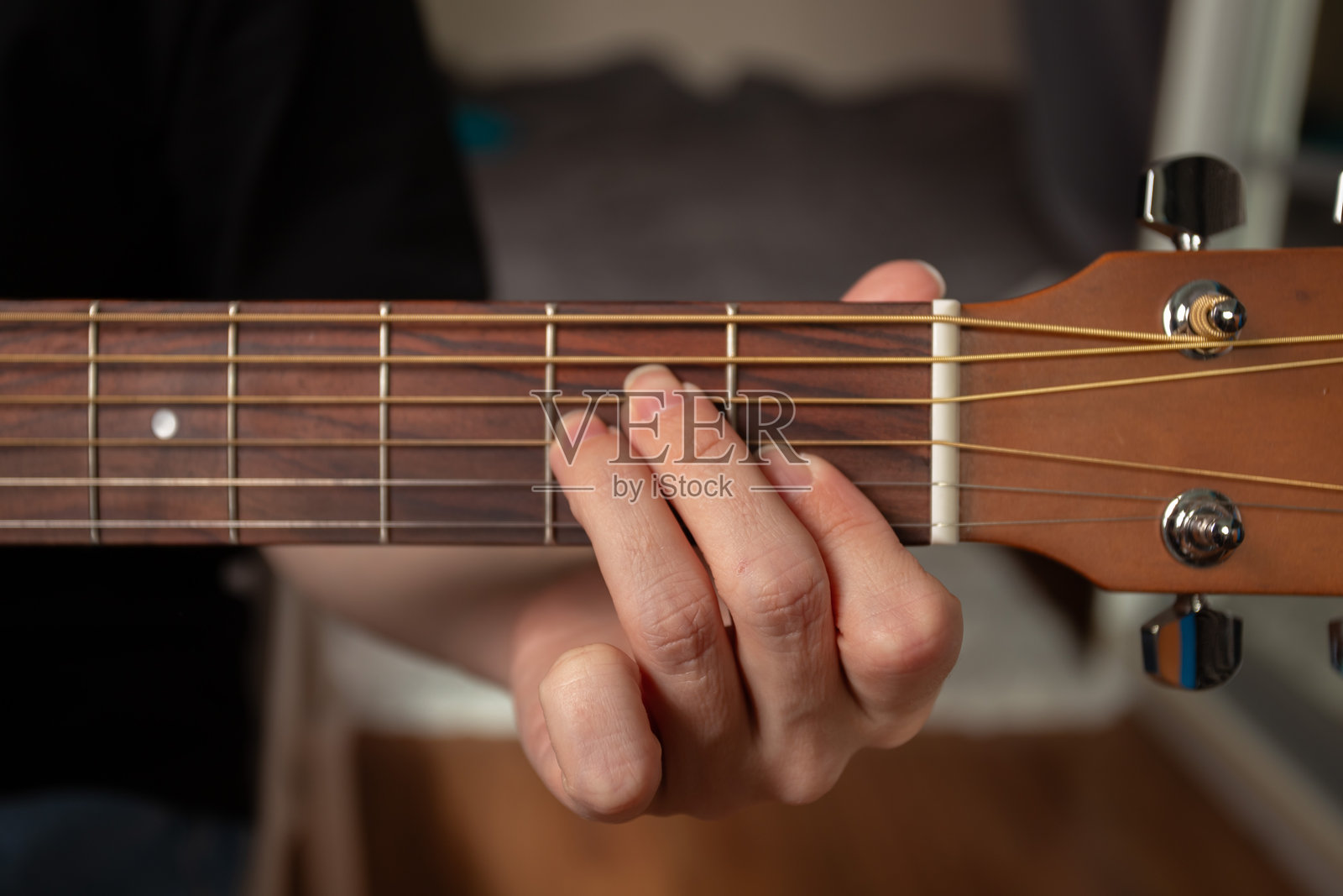手指在木吉他上演奏特写,表演者专注于和弦练习,室内音乐表演,专注于指板照片摄影图片