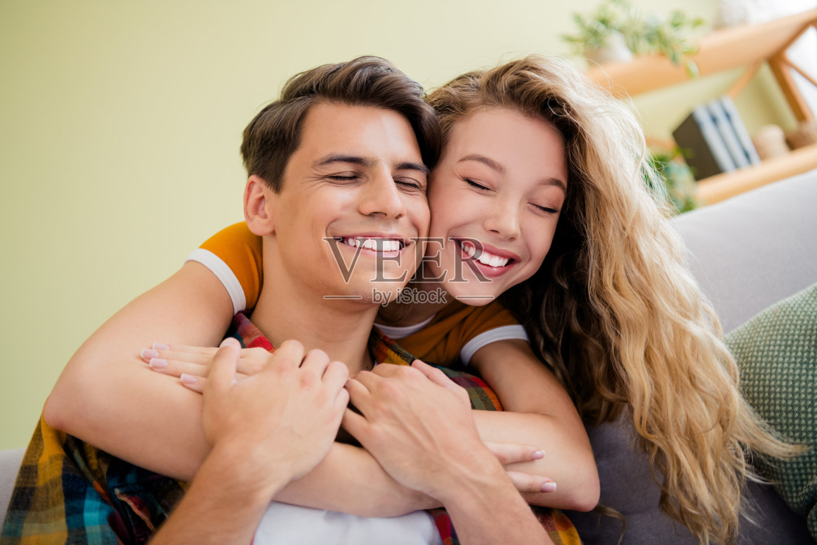 年轻情侣在现代明亮的春季舒适公寓室内拥抱,面带愉快的微笑照片摄影图片