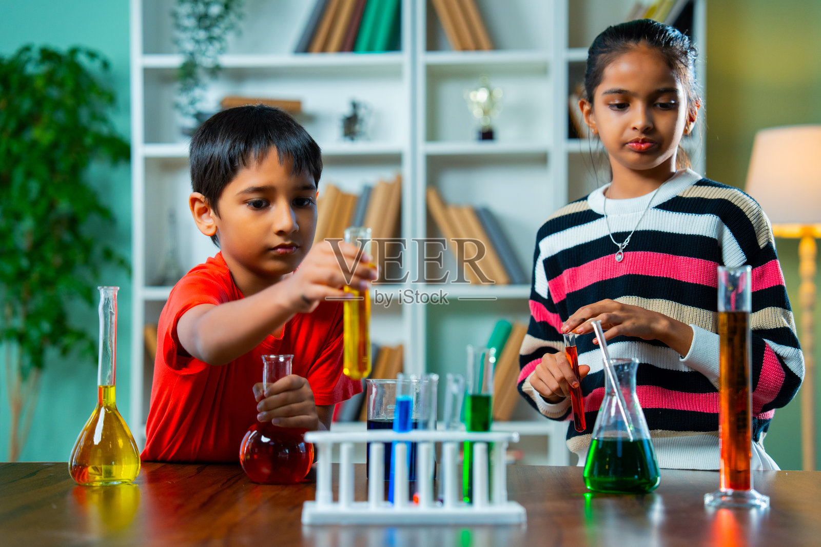 印度孩子们在课堂上用试管和烧杯进行实验,探索基础科学概念照片摄影图片