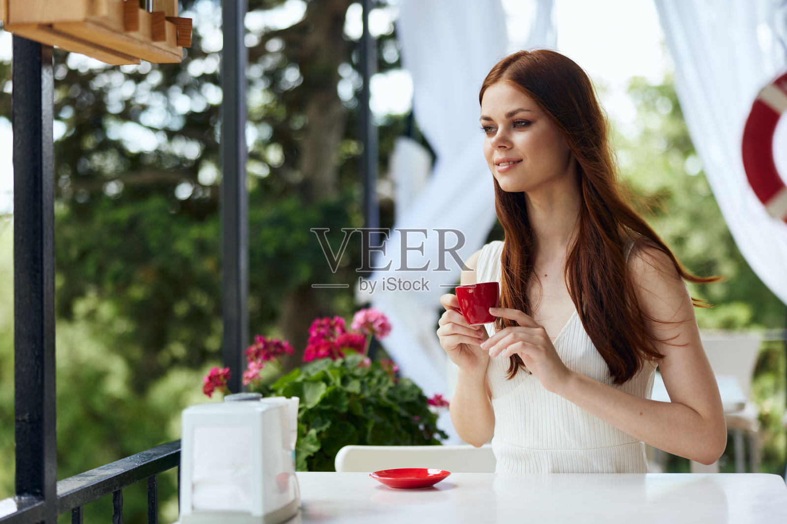 美丽的女人坐在户外咖啡馆享用早餐,放松的概念照片摄影图片