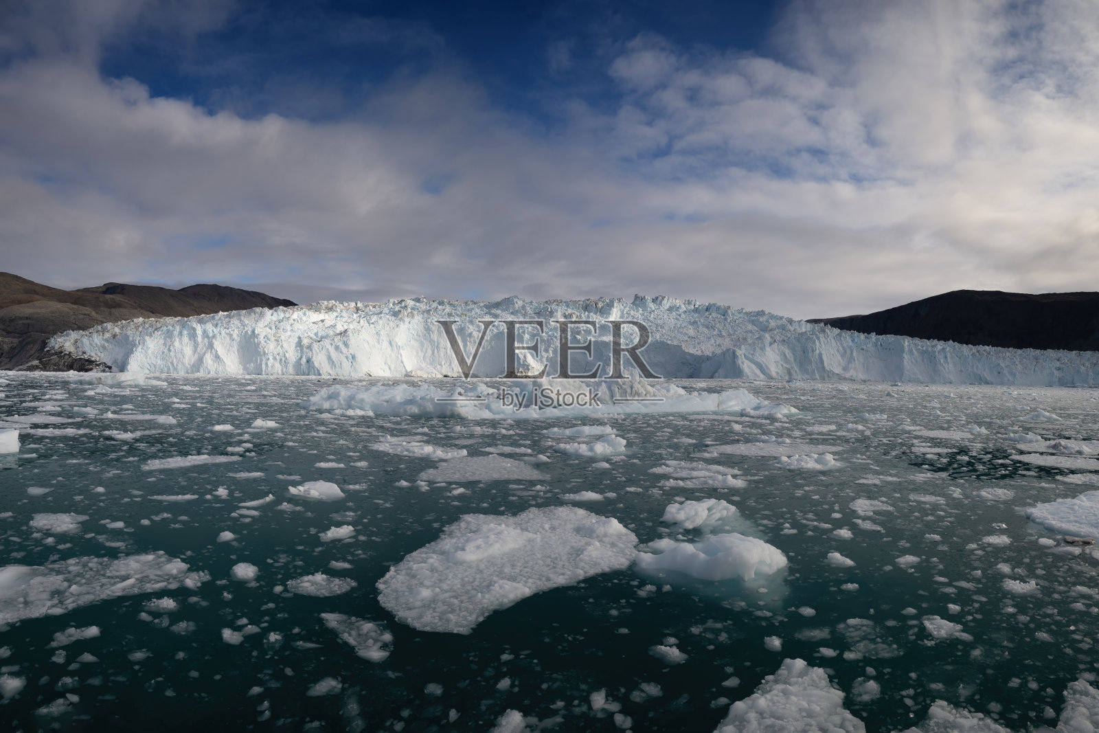 美丽的冰山景观和Eqi冰川的前壁,背景是戏剧性的天空,位于格林兰的伊卢利萨特地区。照片摄影图片