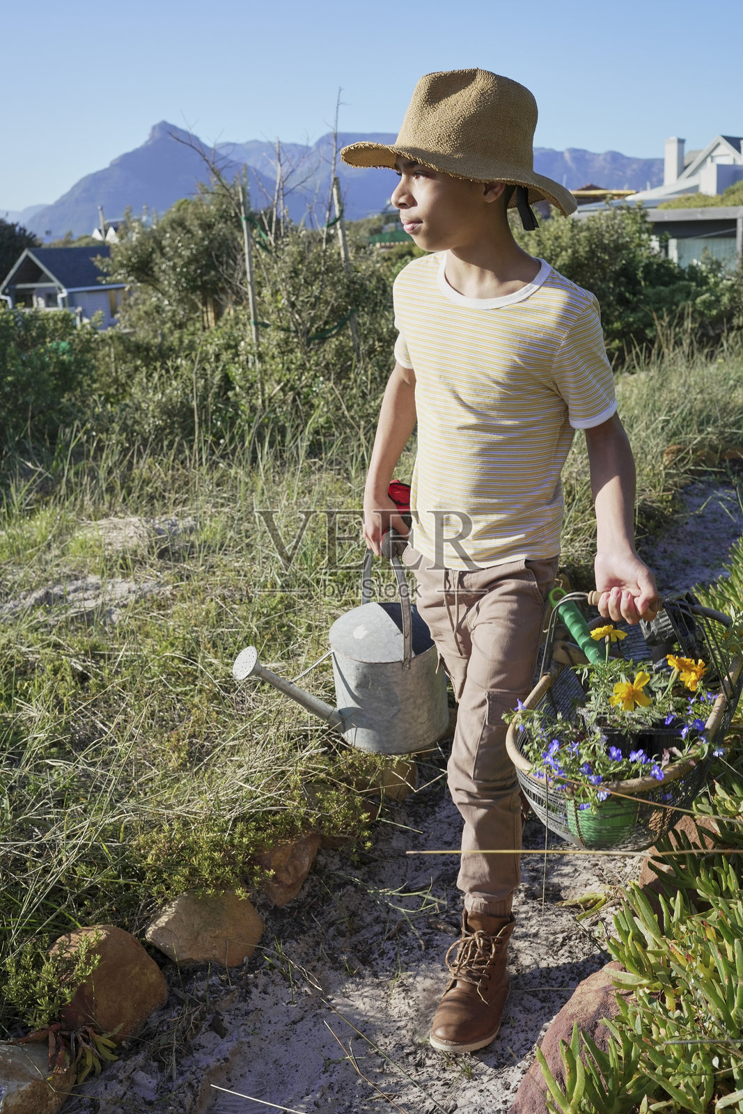 一名使用腿部假肢的少年在园艺。照片摄影图片