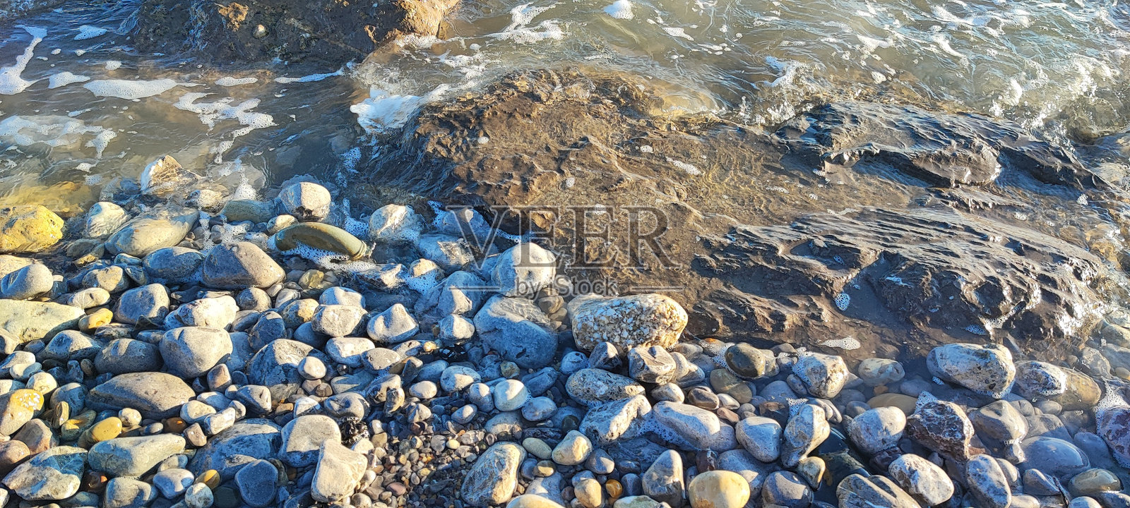 海浪冲刷着英国南威尔士的卵石海滩照片摄影图片