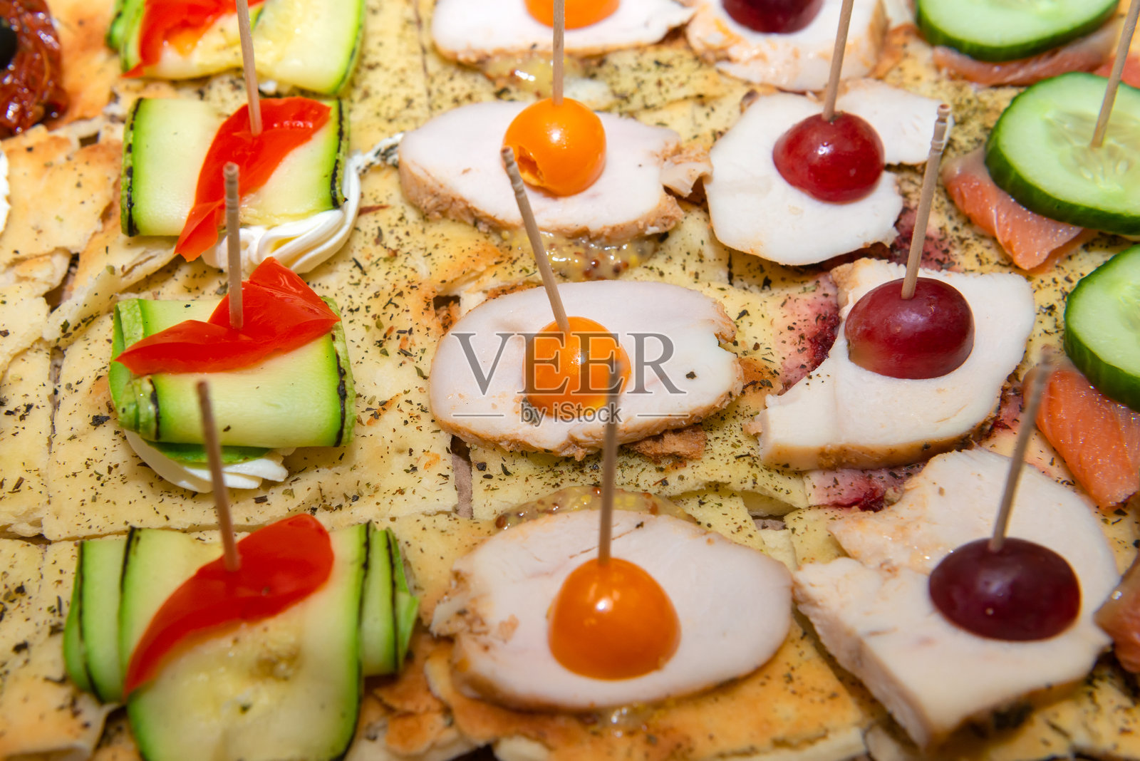 肉类、生菜、奶酪、黄瓜和西红柿的开胃小吃。串上的小吃。照片摄影图片