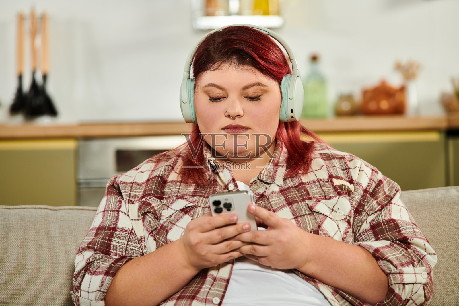 积极身体形象的女性在现代公寓中放松,享受音乐。照片摄影图片