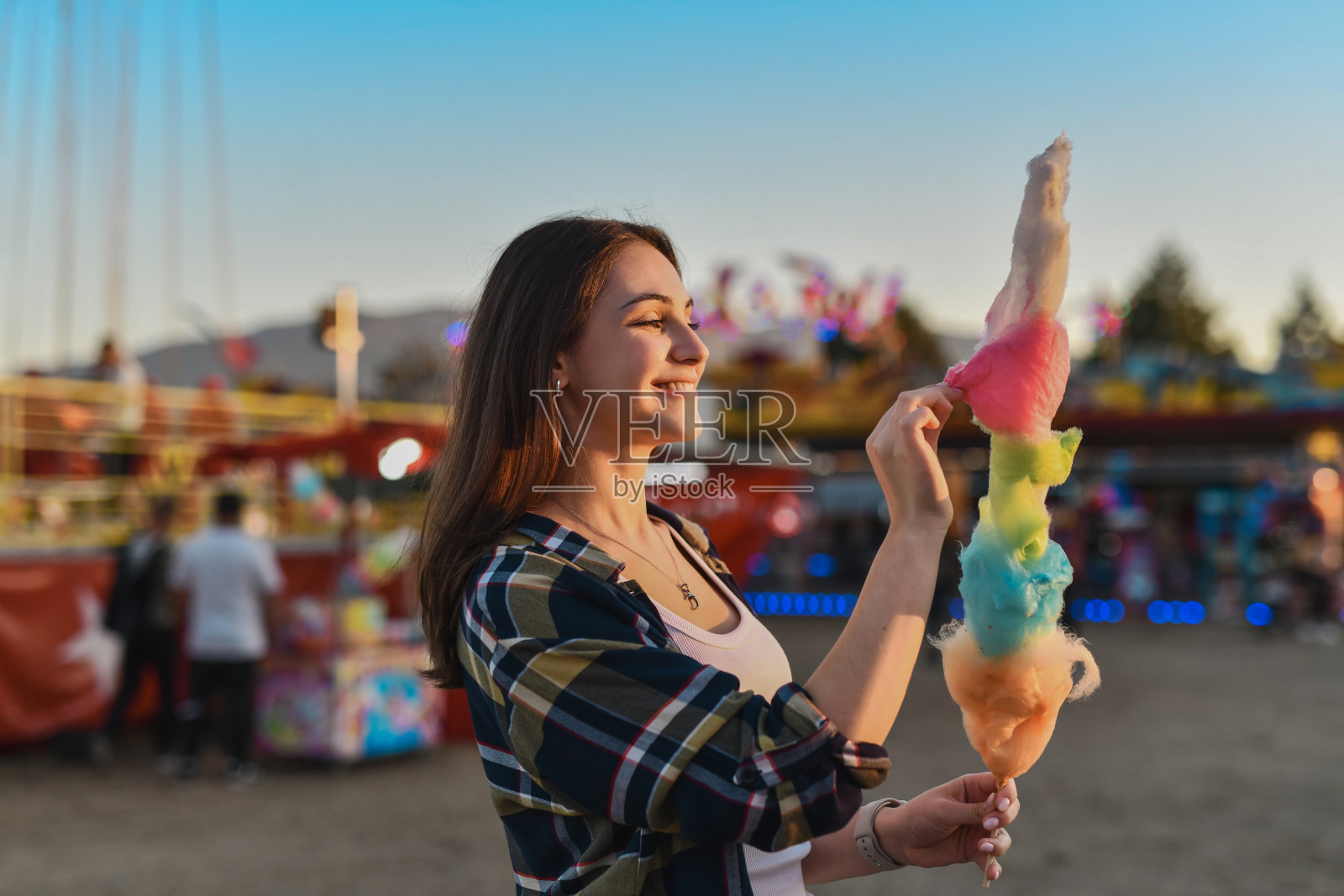 兴奋的女性在游乐园尝试五彩缤纷的棉花糖照片摄影图片