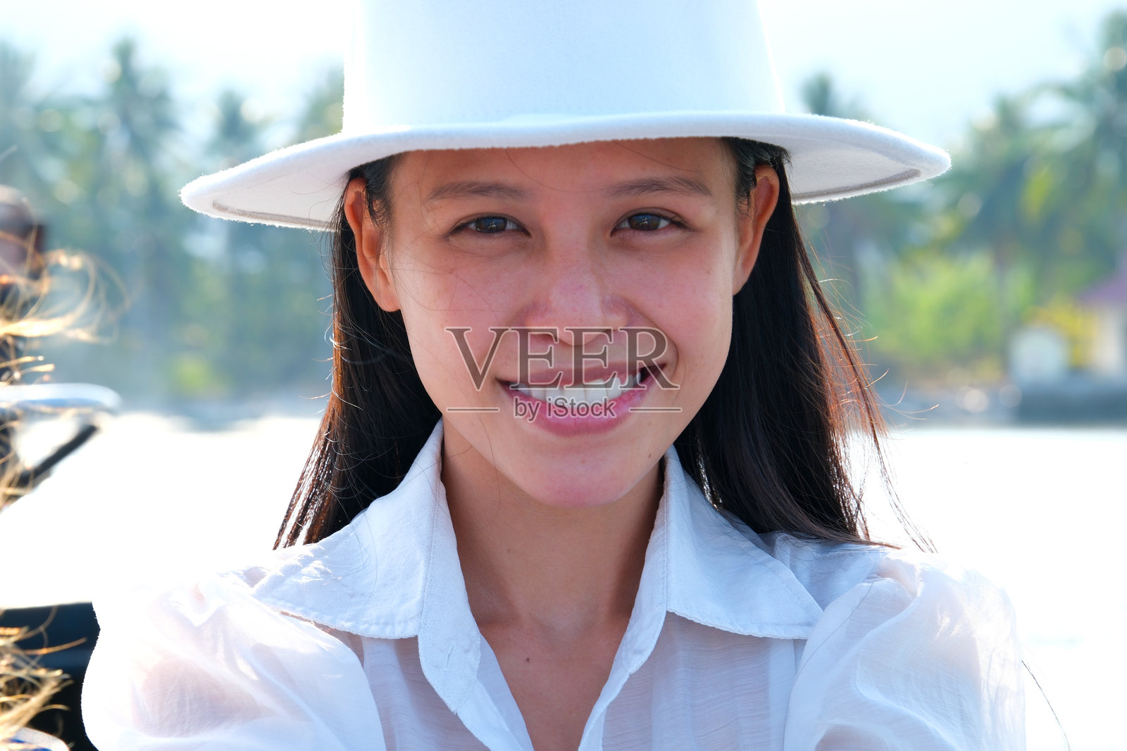 身穿白色衣服的越南女孩,戴着白色帽子,经典的亚洲美人在湖边,优雅的年轻女士。照片摄影图片