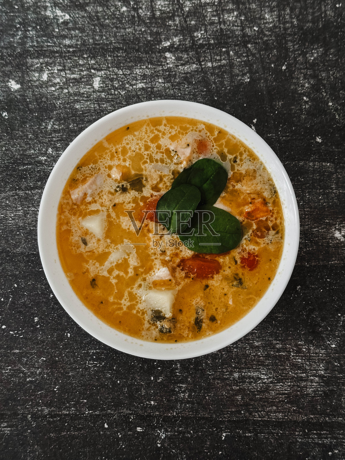 黑色背景上的白色盘子里的汤照片摄影图片