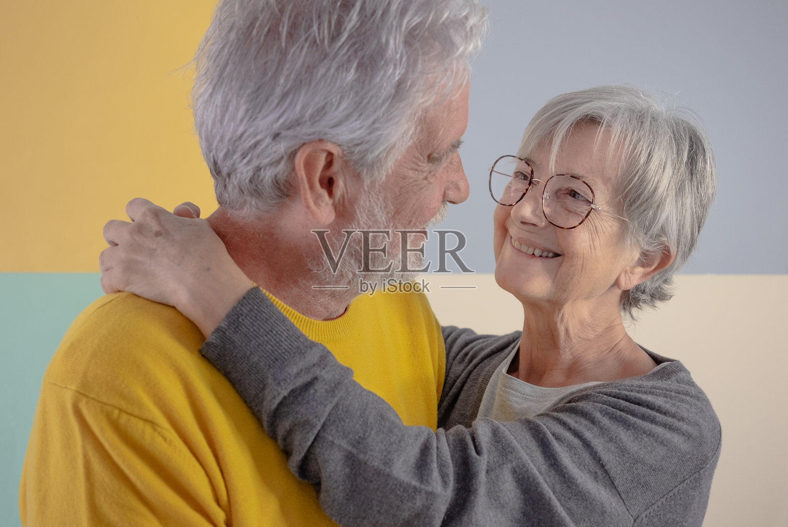 一对微笑的白人老年夫妇温柔相拥,深情对视。照片摄影图片