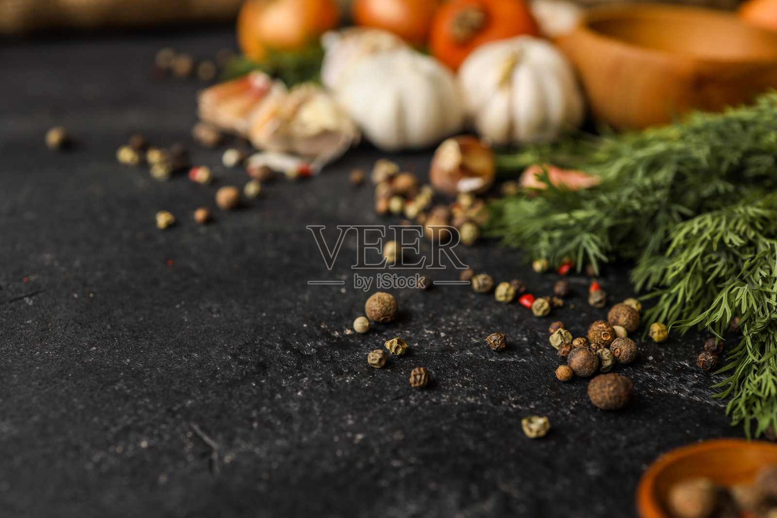 新鲜洋葱、大蒜、莳萝和胡椒粒从上方俯视,排列在深色纹理背景上,留有充足的空白空间。非常适合食品造型、烹饪项目和有机食材主题。照片摄影图片