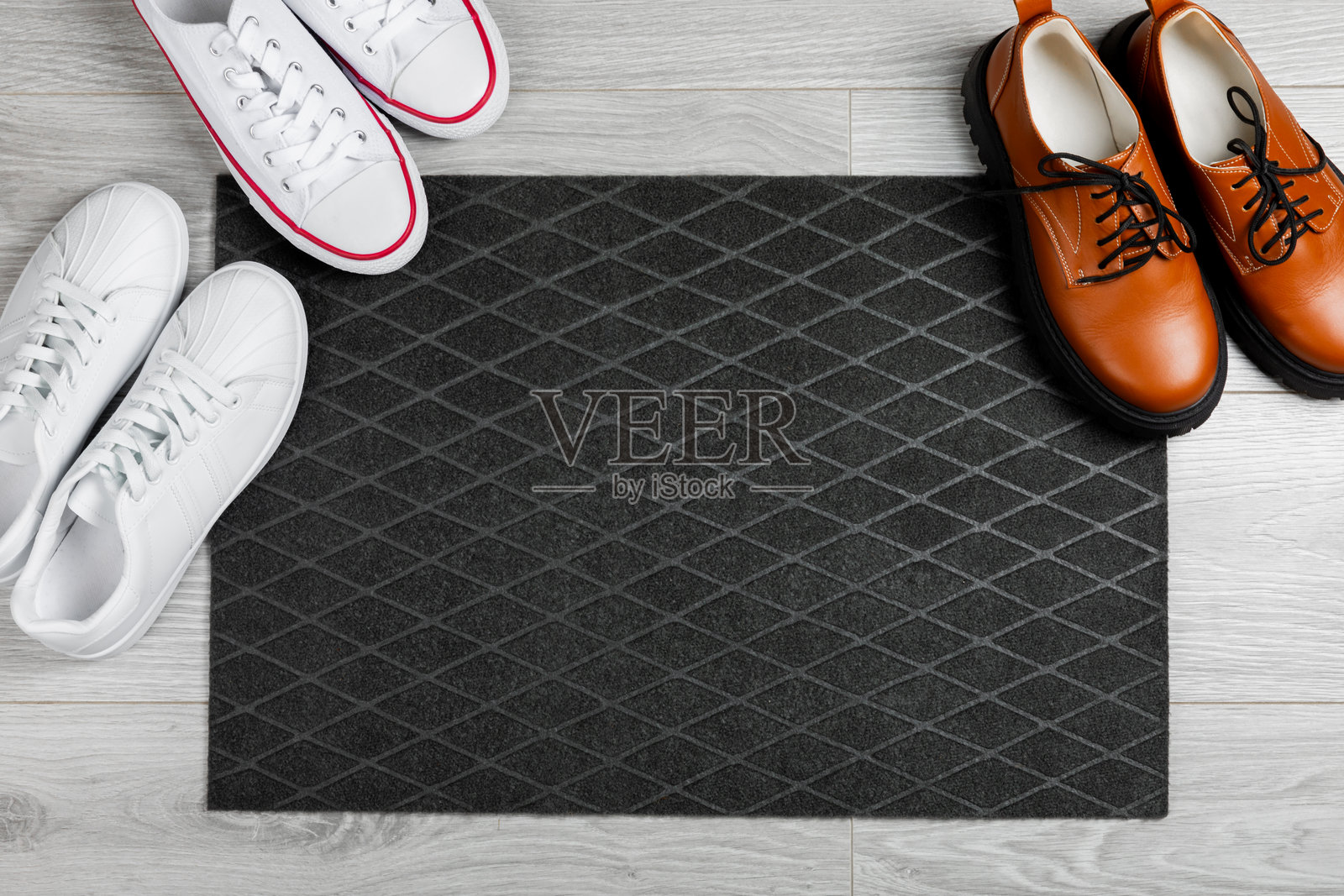 门垫。地板上的欢迎垫。女性鞋子放在门垫上,背景为室内装饰元素。特写。留白空间。走廊门口的地毯。照片摄影图片