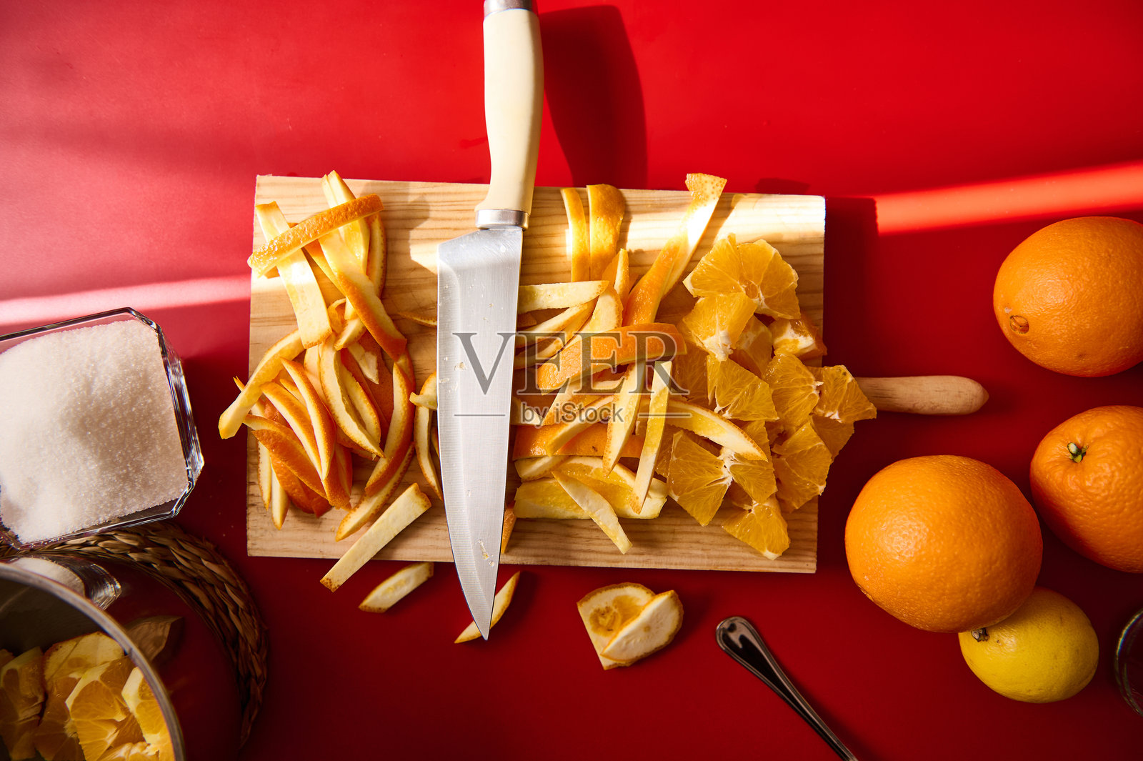 新鲜切好的橙皮和橙瓣,刀放在木砧板上照片摄影图片
