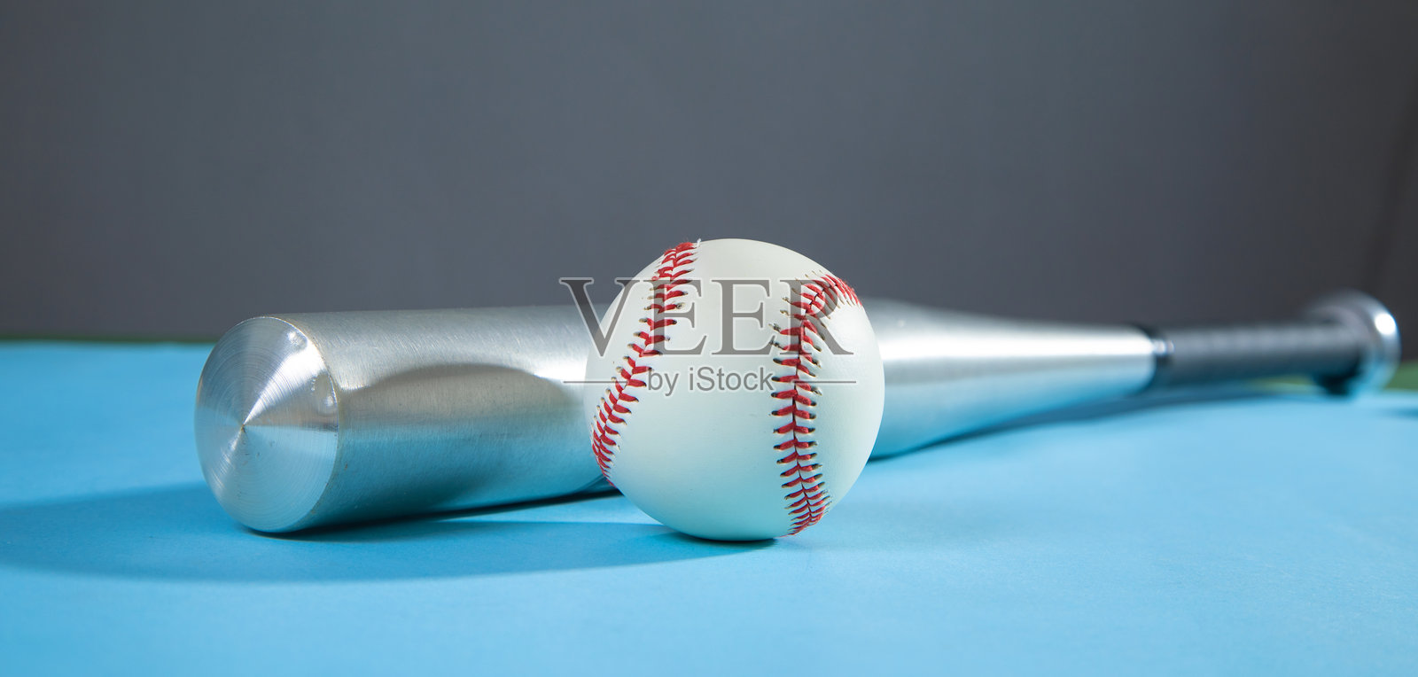 蓝色背景上的棒球棒和棒球。照片摄影图片