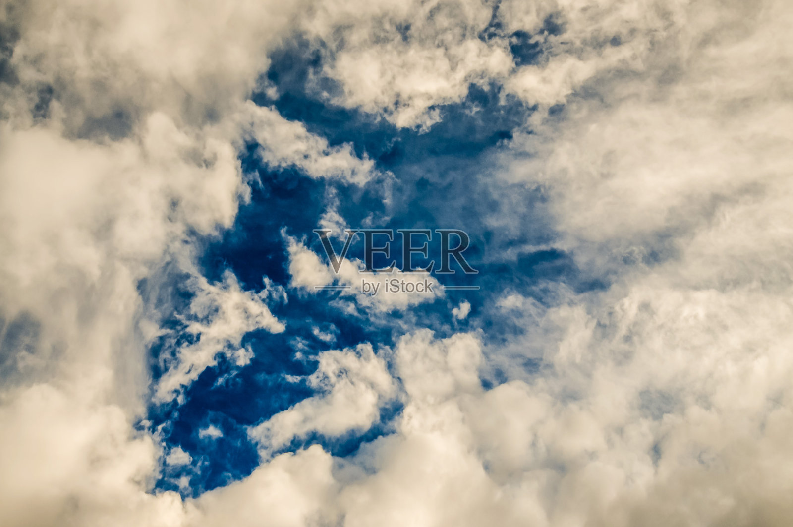 天空湛蓝,点缀着几朵云彩。照片摄影图片