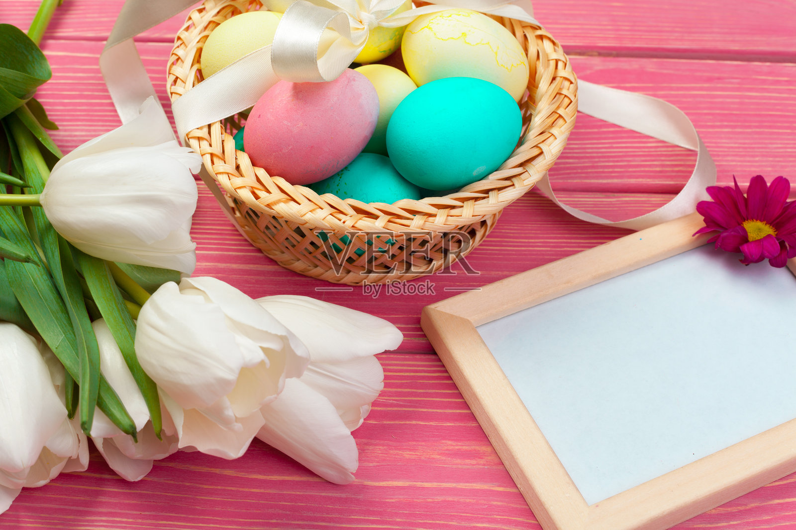彩色鸡蛋和郁金香花朵在木板背景上照片摄影图片