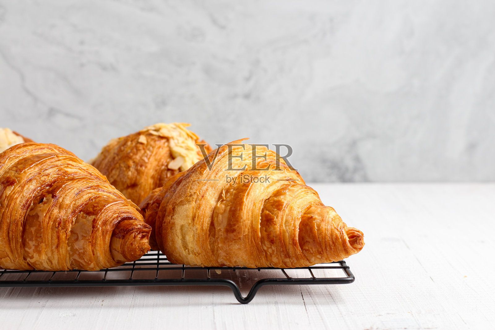 冷却架上的可颂 pastry。照片摄影图片