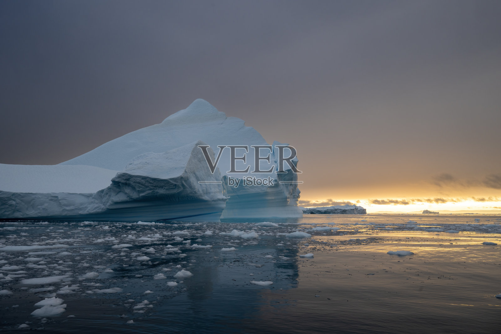 格林兰伊卢利萨特迪斯科湾的蓝色冰山与美丽的橙色日落景观照片摄影图片