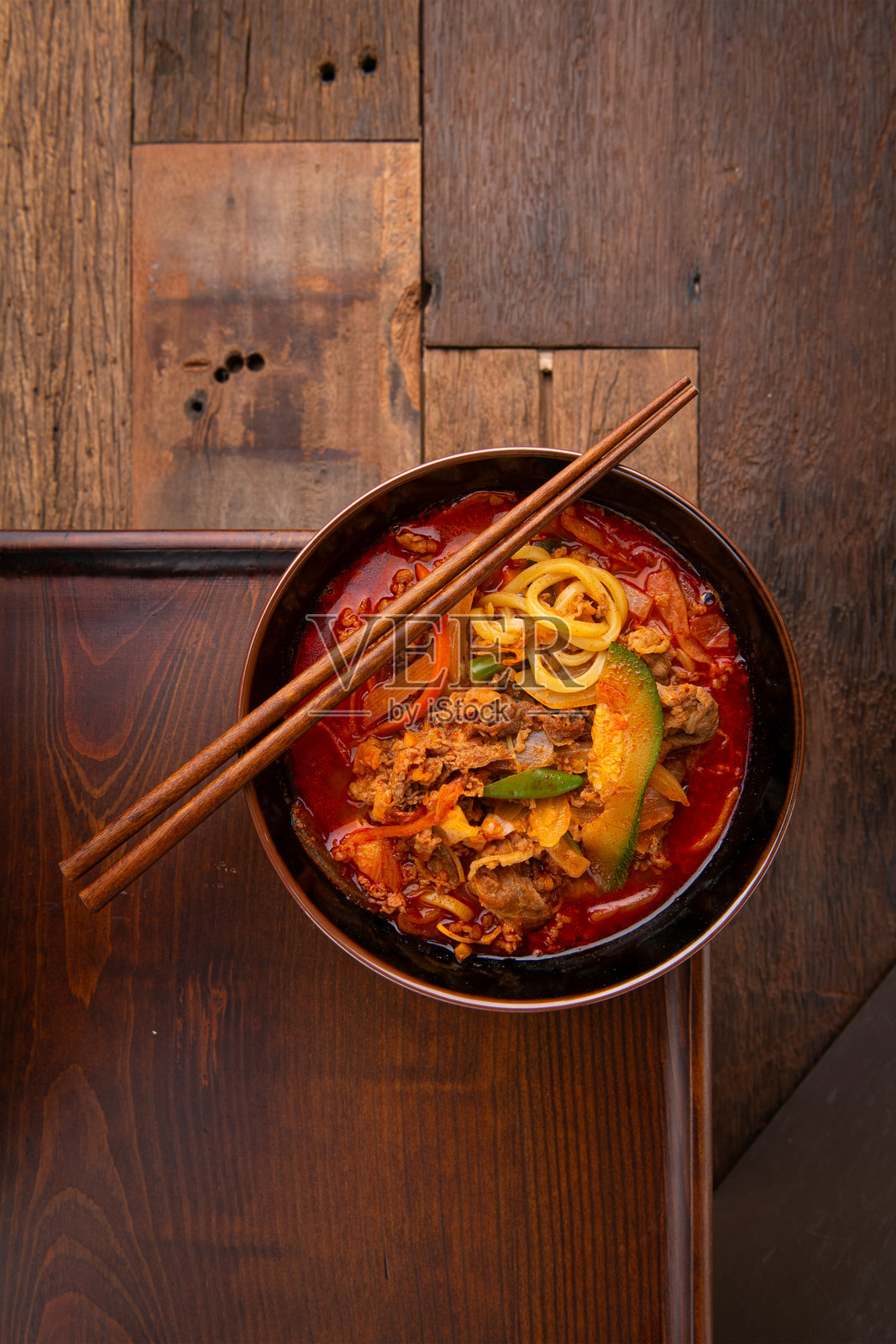 桌子上的辣味拉面、蔬菜和肉类照片摄影图片