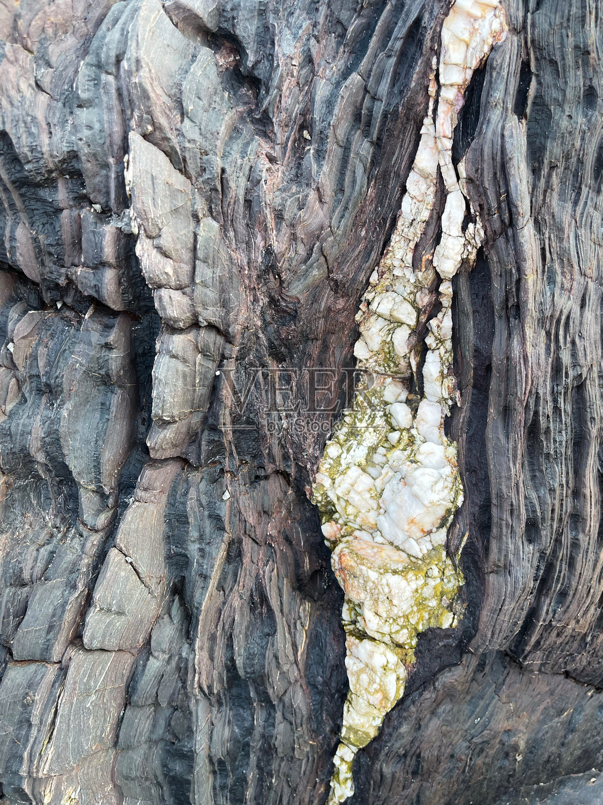 自然破碎岩石的纹理和图案,以及海水随时间造成的侵蚀。照片摄影图片
