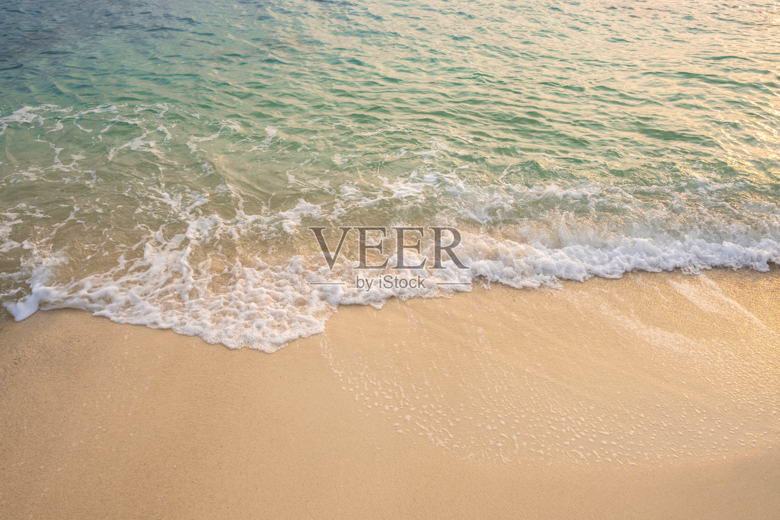 从上方俯瞰沙滩和蓝色海水,阳光明媚的夏天,闪闪发光的海水。沙滩沙子背景适合夏季度假概念。照片摄影图片