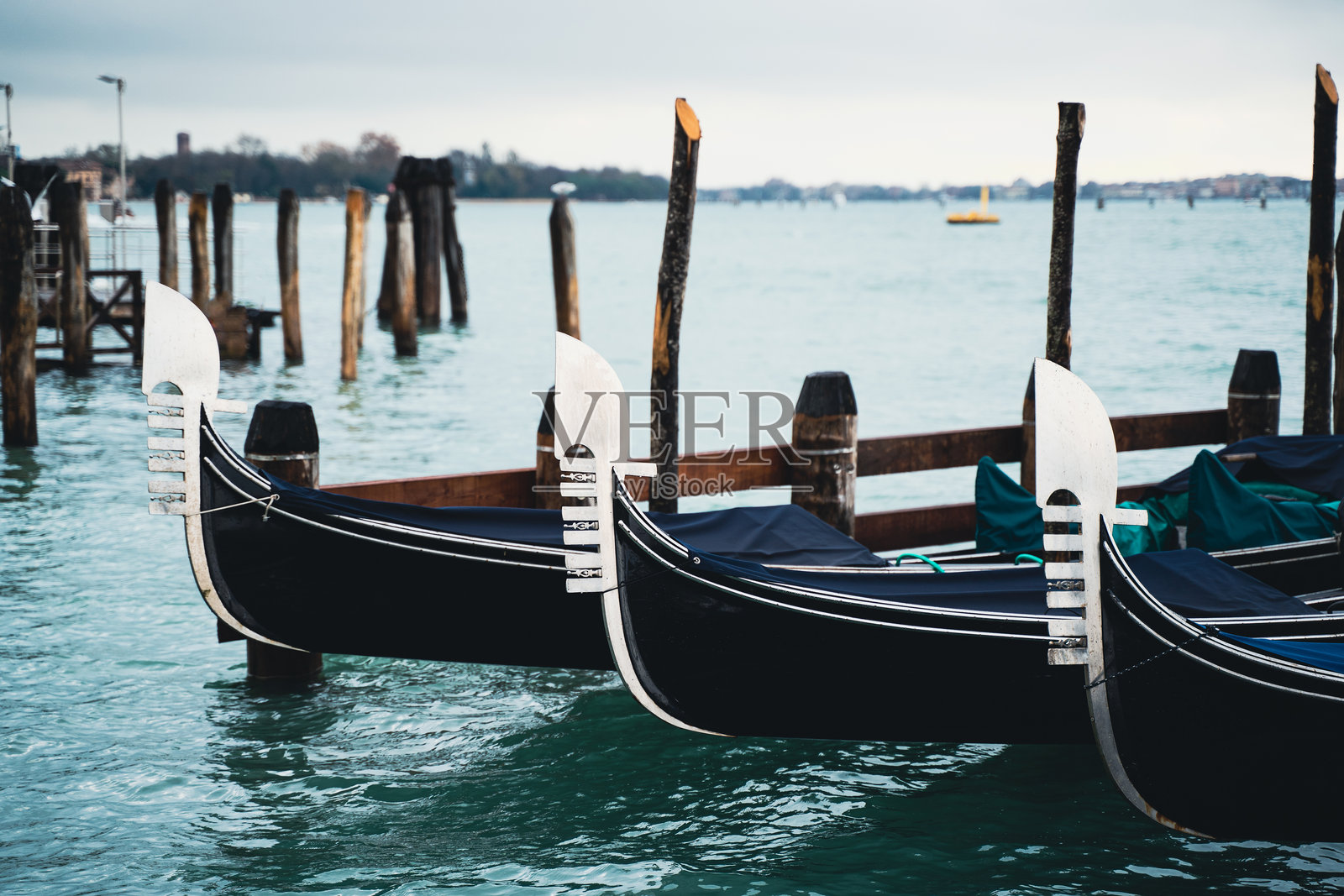 威尼斯的贡多拉停靠在阴云密布的平静水面上照片摄影图片
