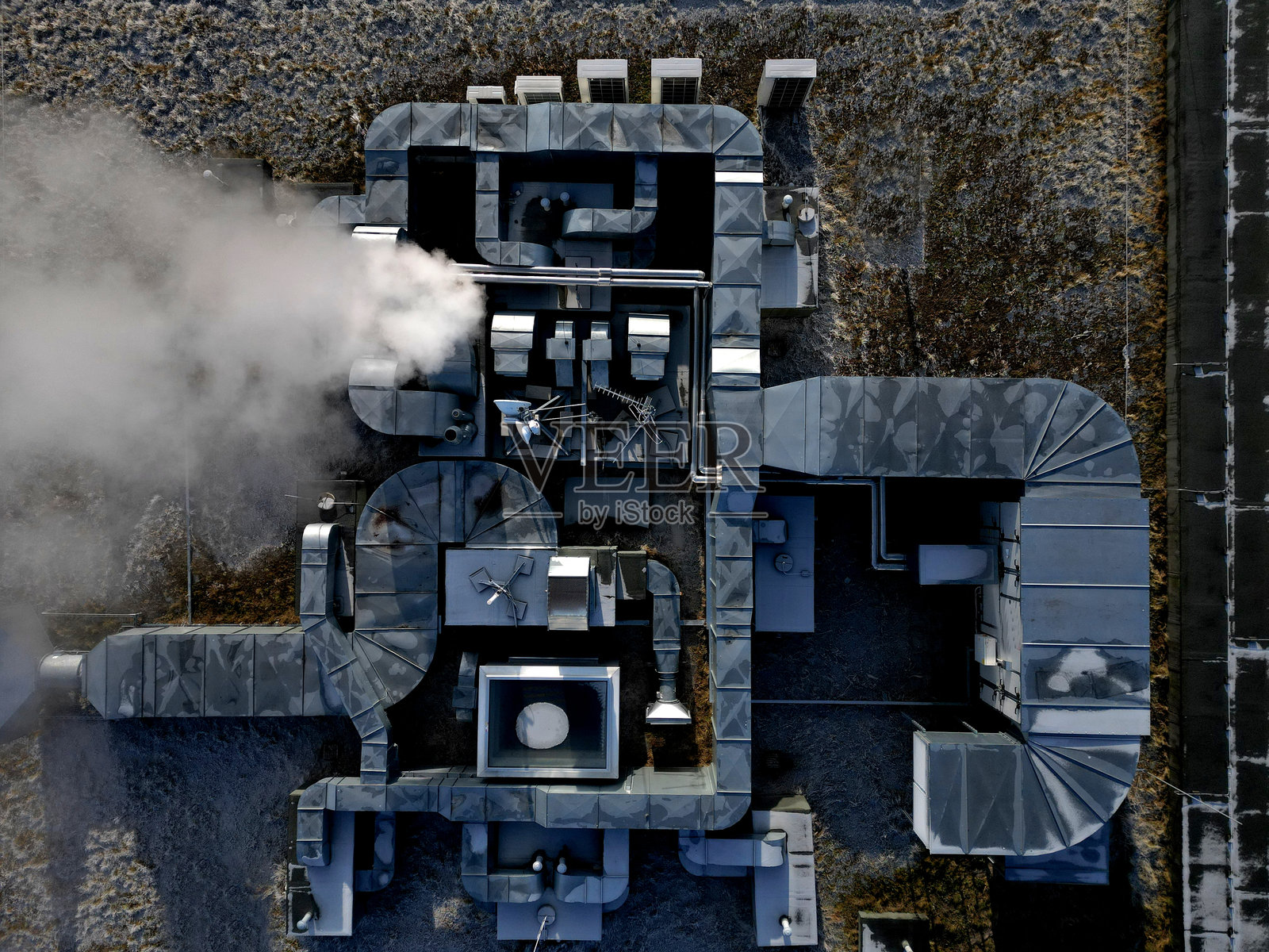 在工业建筑屋顶上安装钢制空调管道照片摄影图片