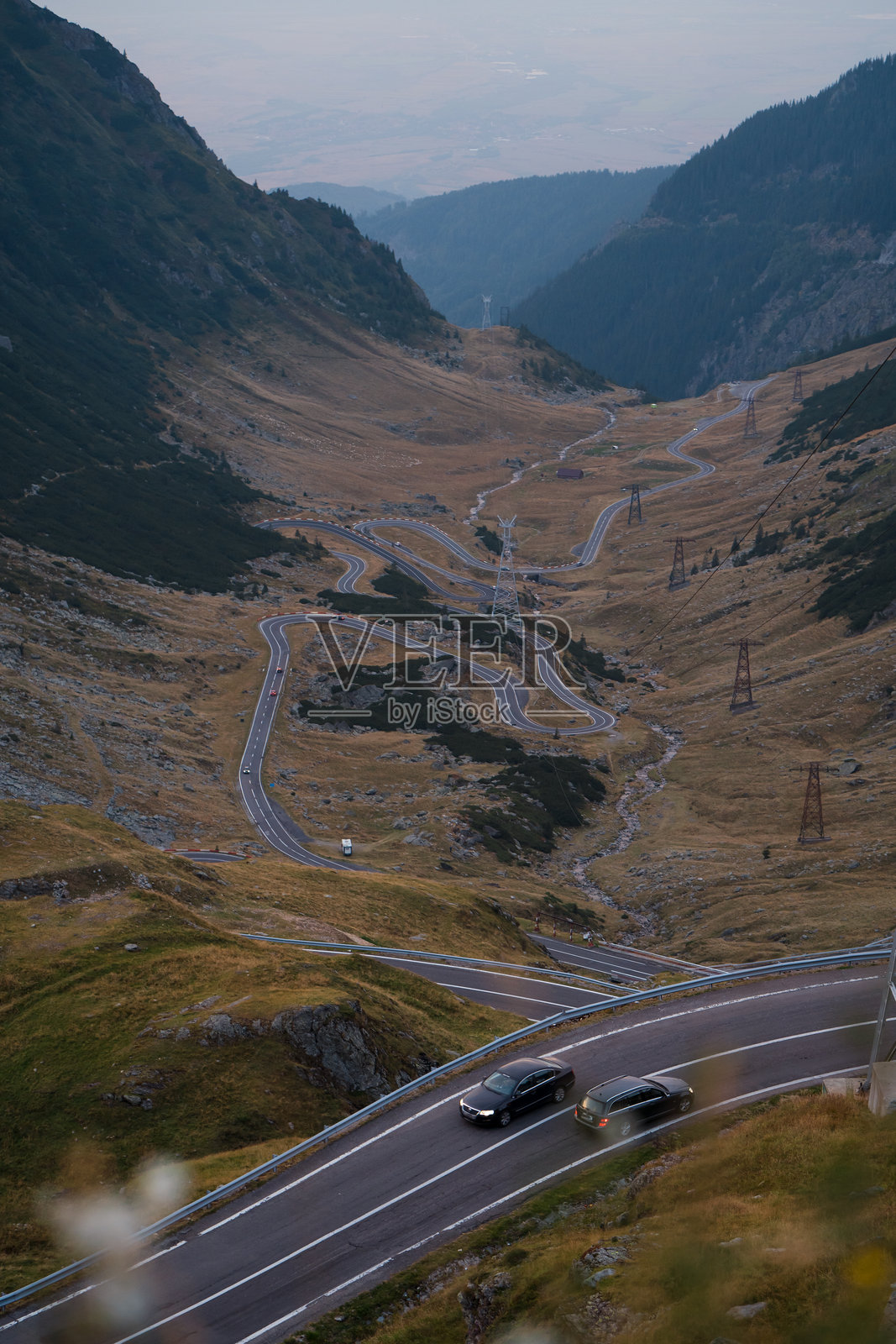 一张令人惊叹的无人机拍摄的罗马尼亚特兰西瓦尼亚的特兰法加拉山公路,展示了其令人屏息的曲线和壮丽的风景。照片摄影图片