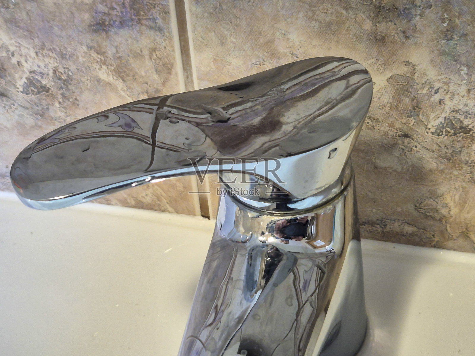 现代铬合金水龙头的特写,突显其流线型设计和光亮的表面,完美适用于厨房或浴室环境。照片摄影图片