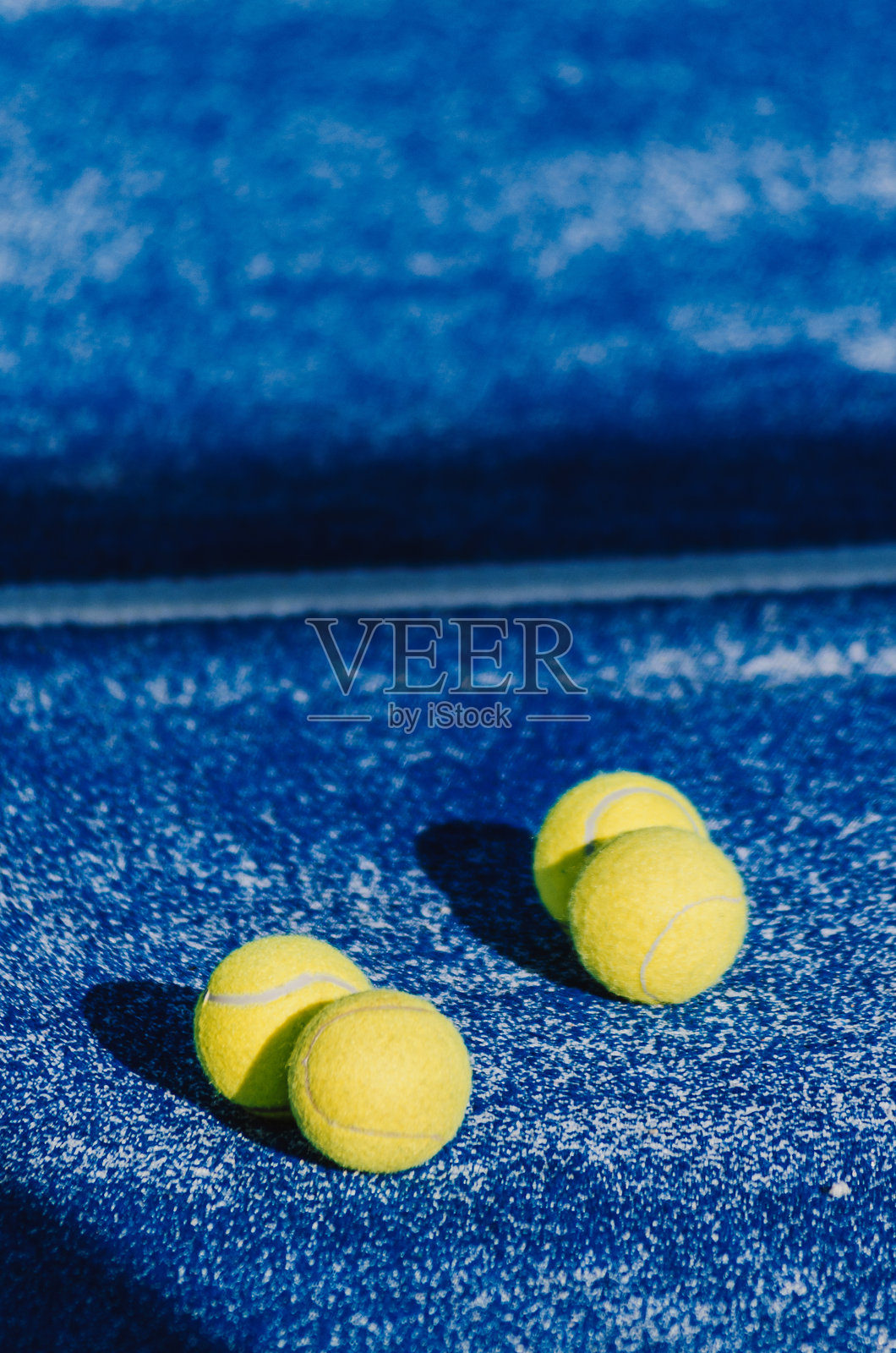 四个帕德尔球在蓝色的帕德尔网球场上,球拍运动概念背景照片摄影图片