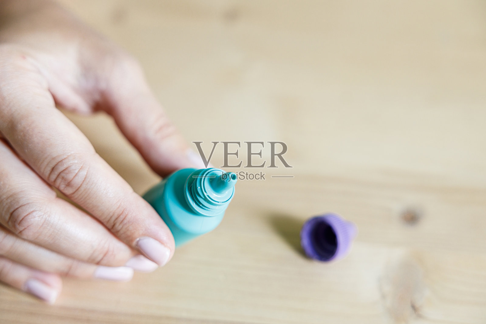 女人的手握着眼药水照片摄影图片