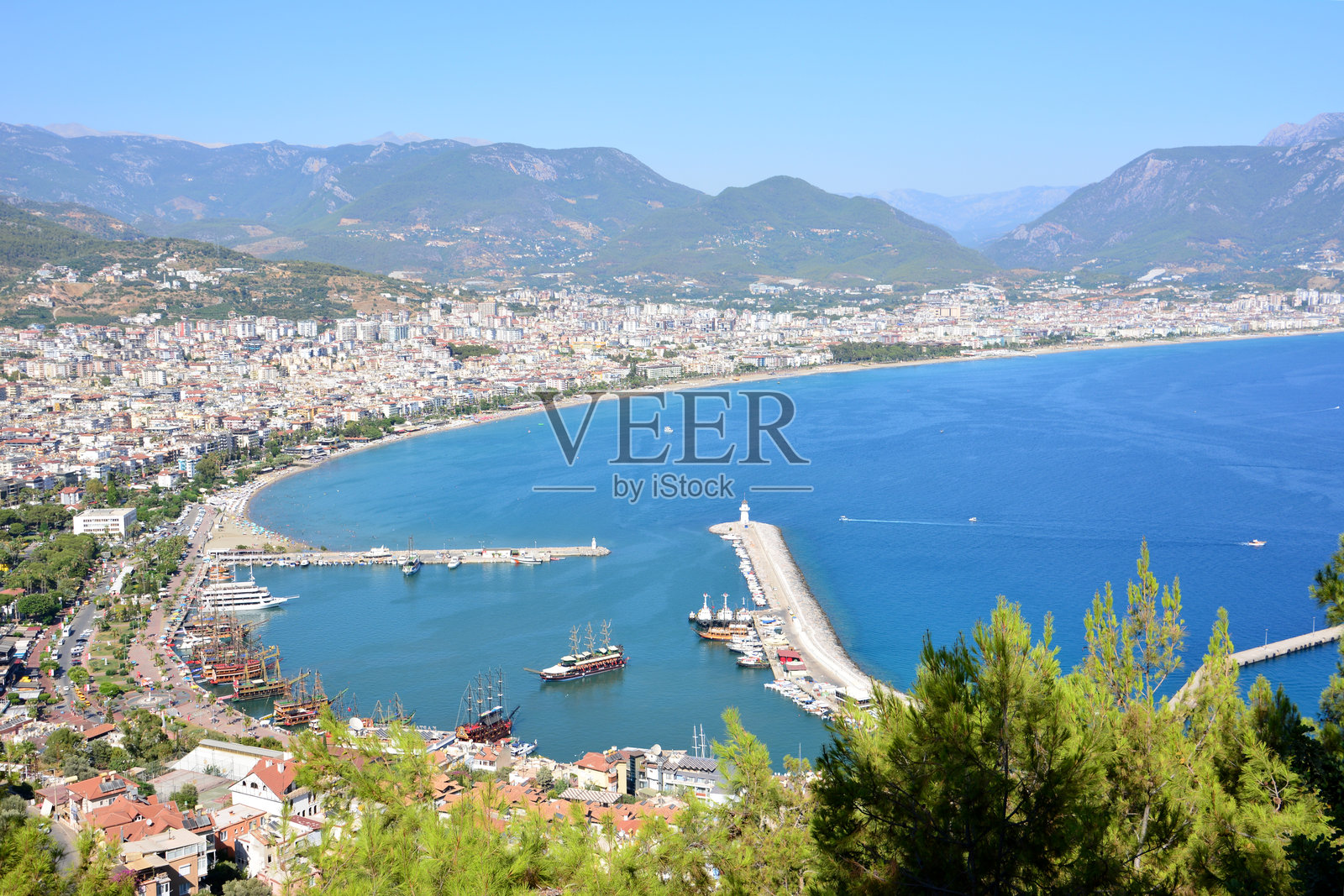 土耳其阿拉尼亚背景下的蓝色海洋与水中的船只照片摄影图片