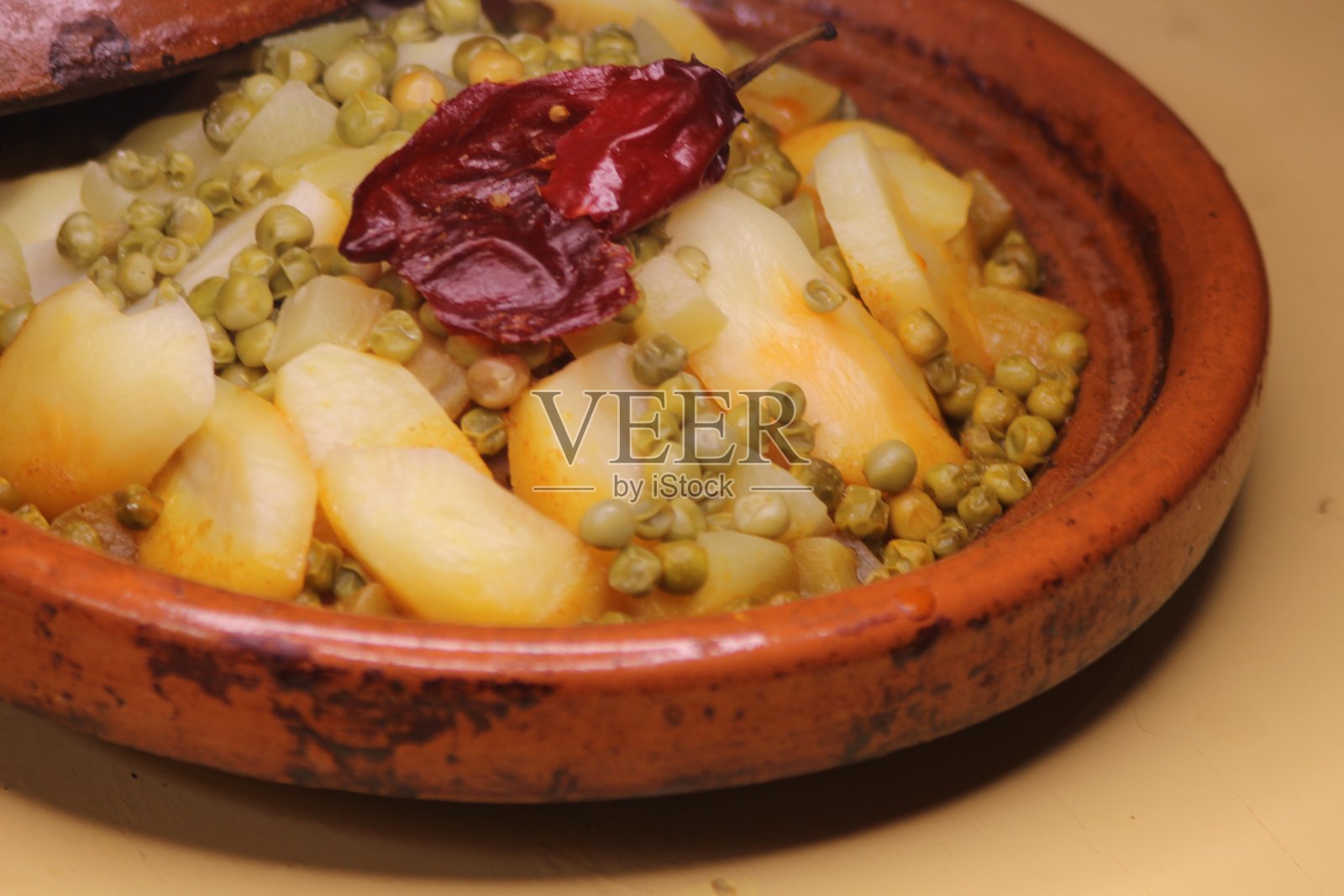 新鲜的塔吉锅配土豆和豌豆照片摄影图片