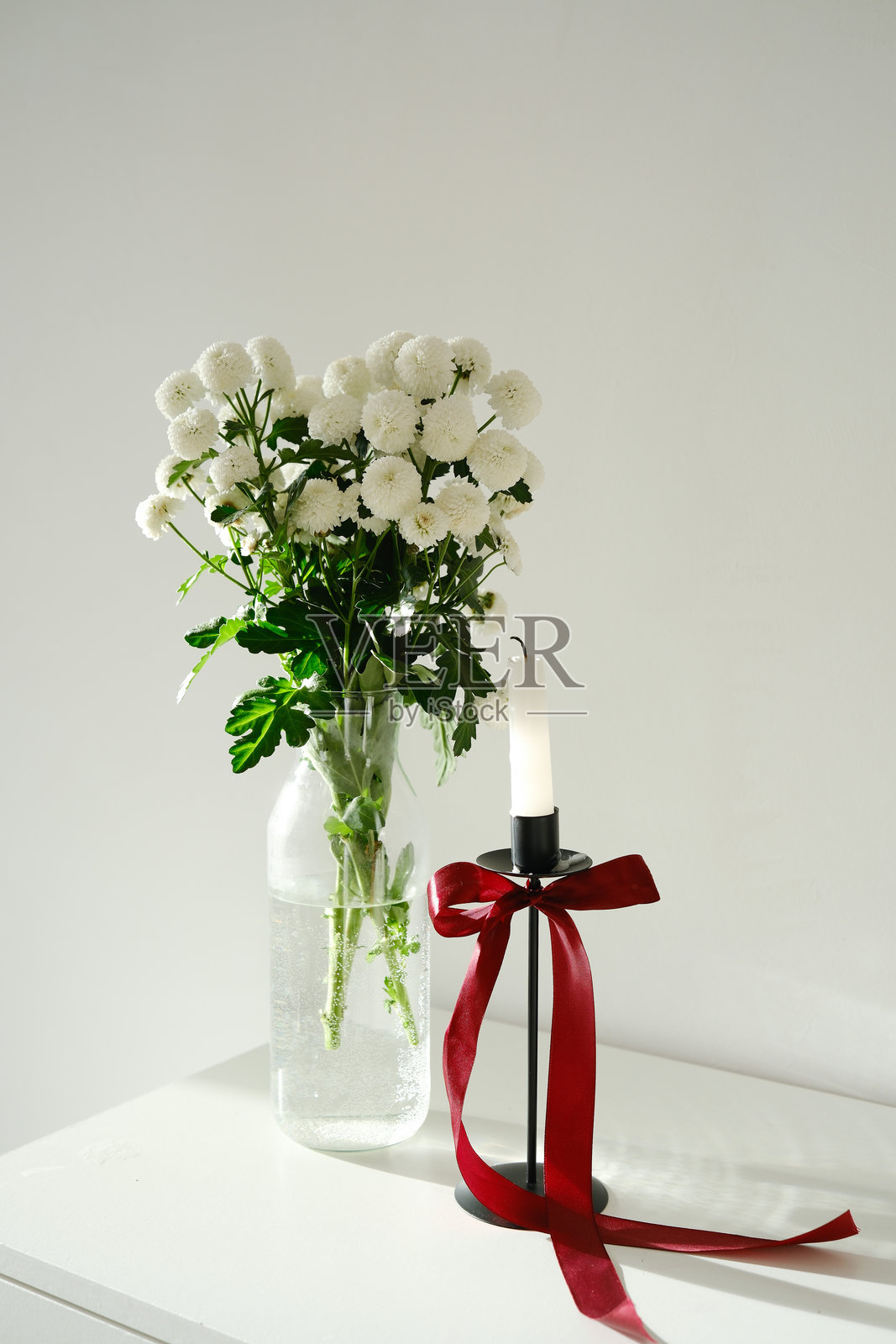 白色花束,白色桌子上的蜡烛。节日氛围。照片摄影图片