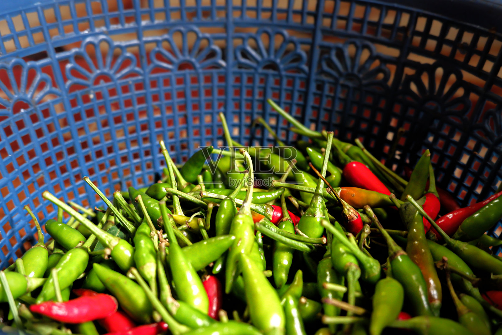 篮子里堆满了绿色和红色的辣椒照片摄影图片
