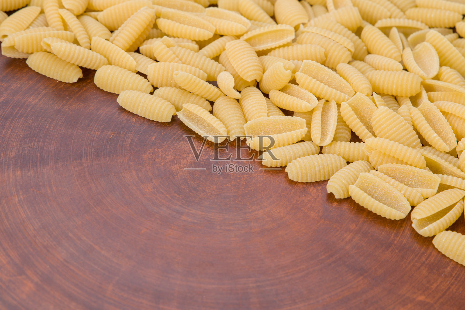 未煮的意大利土豆饺子特写,背景为木质表面照片摄影图片