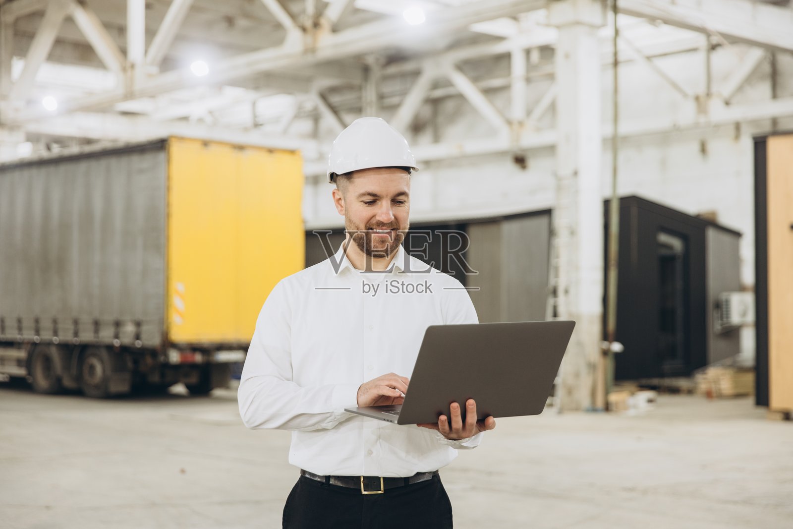 工程师在模块化建筑工厂使用笔记本电脑照片摄影图片