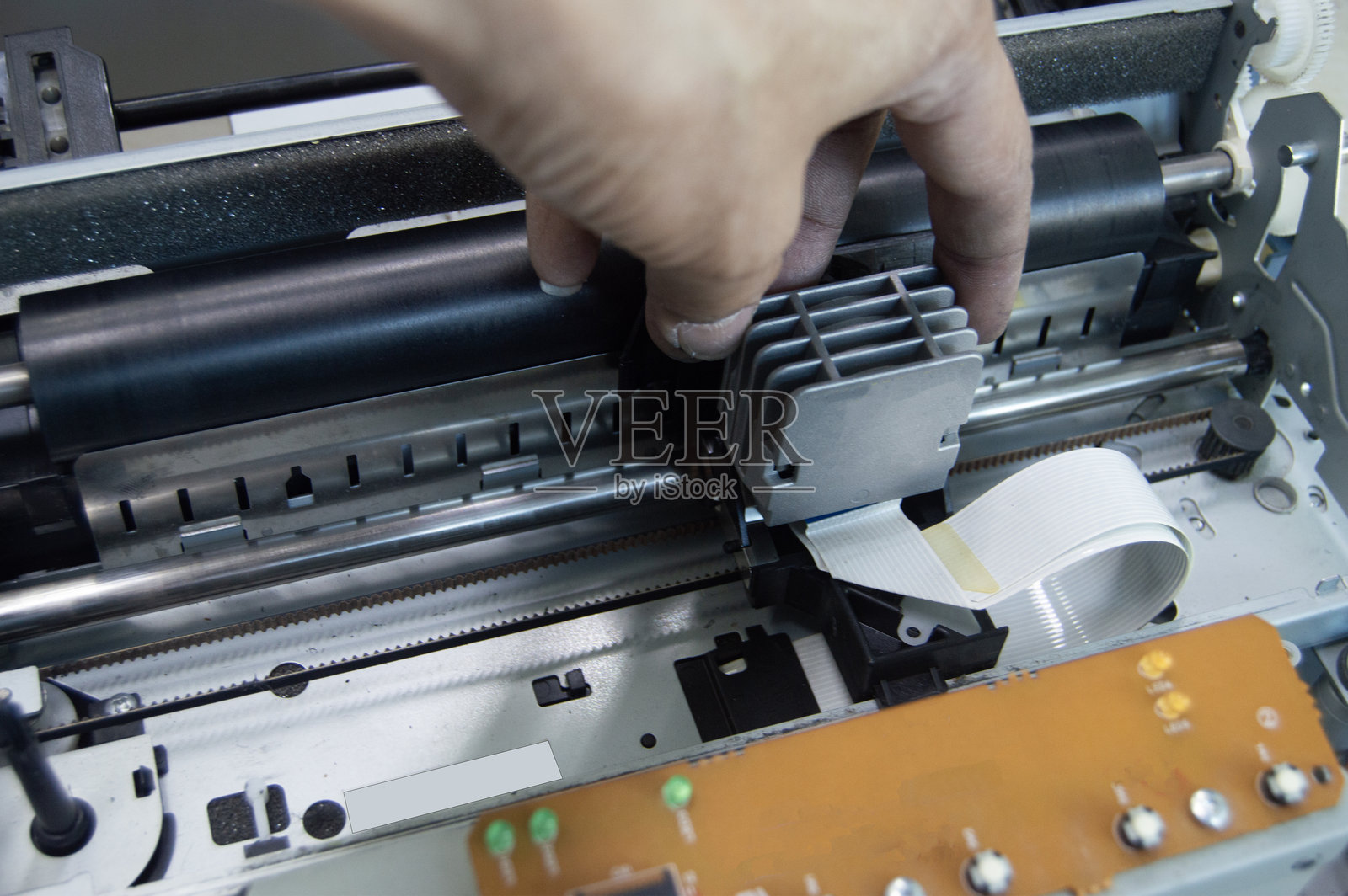 技术人员从上方查看并修理打印机。照片摄影图片