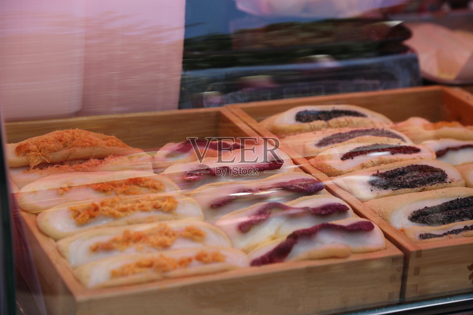 不同种类的传统糕点,整齐地摆放在户外食品市场摊位的木箱中照片摄影图片