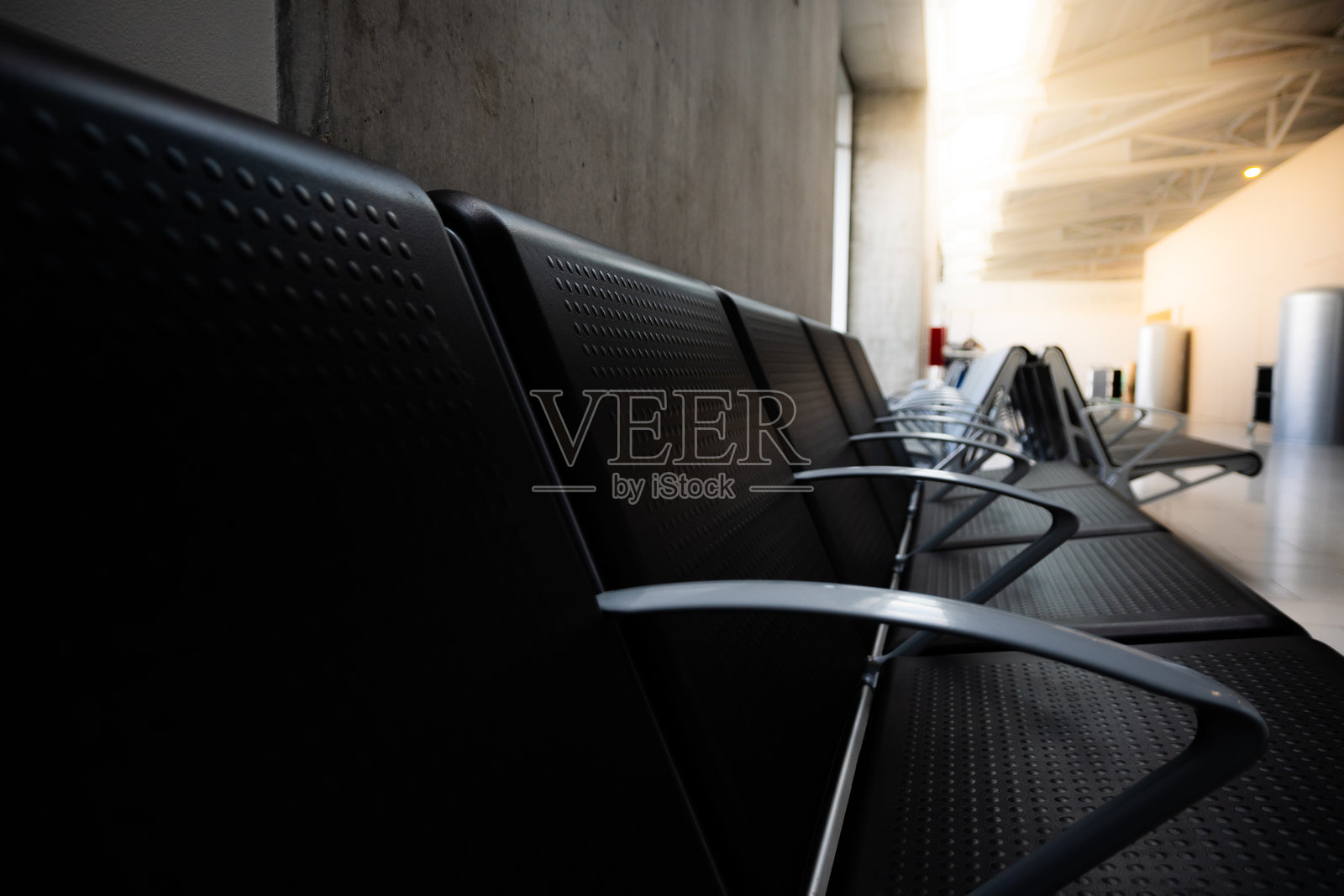 机场航站楼候机区的空座位,靠近登机口。象征着航班延误、候机室中转和现代交通枢纽舒适感的旅行概念。照片摄影图片