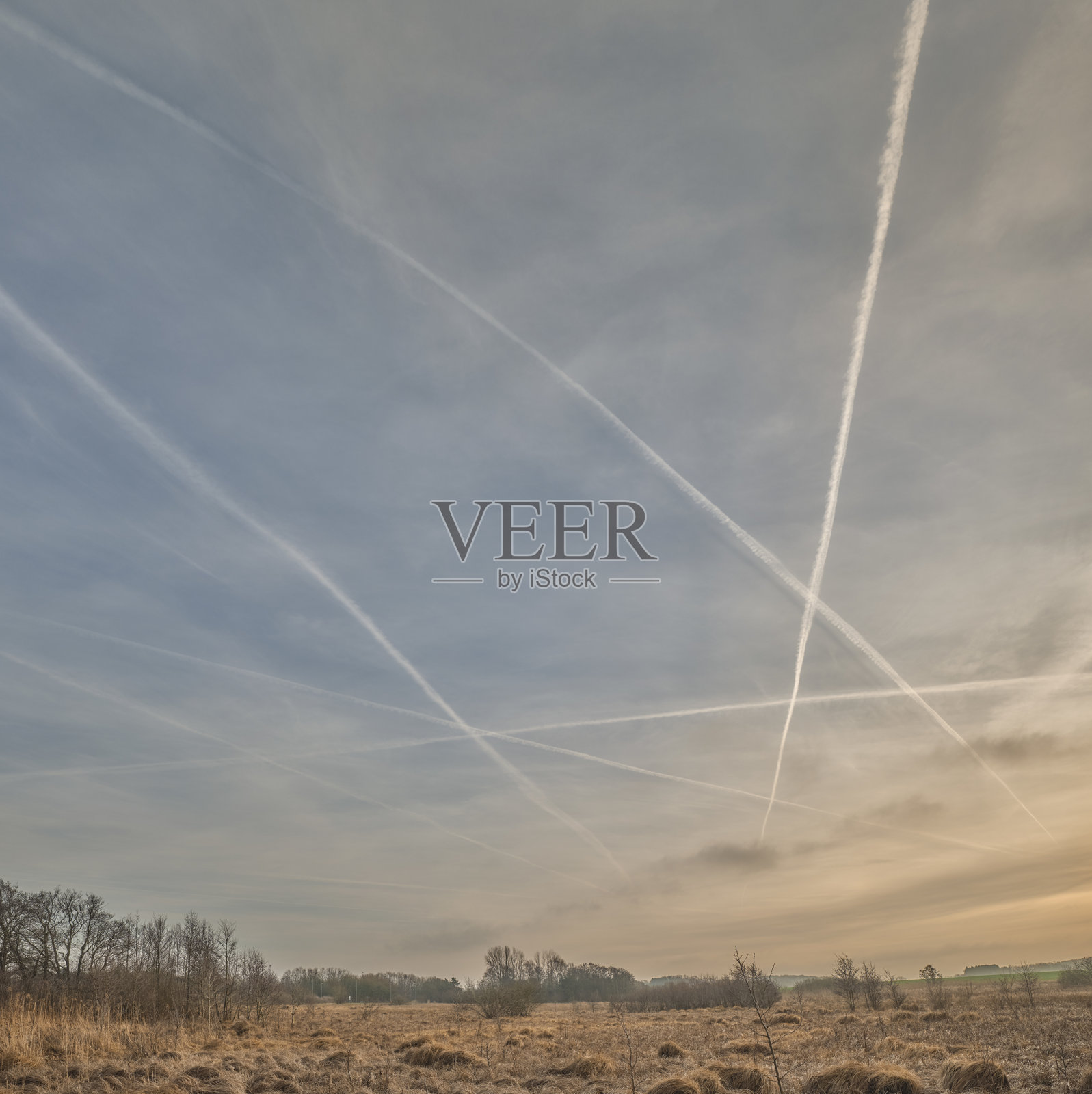 丹麦风景上冬季日出,天空中有飞机尾迹照片摄影图片